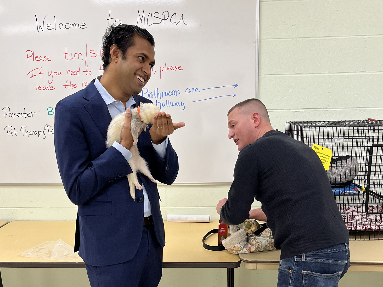 New Jersey Senator Vin Gopal, left, holds a ferret while visiting with Matty Giuliano at the Monmouth County SPCA. (Photo courtesy Michael Illiano)