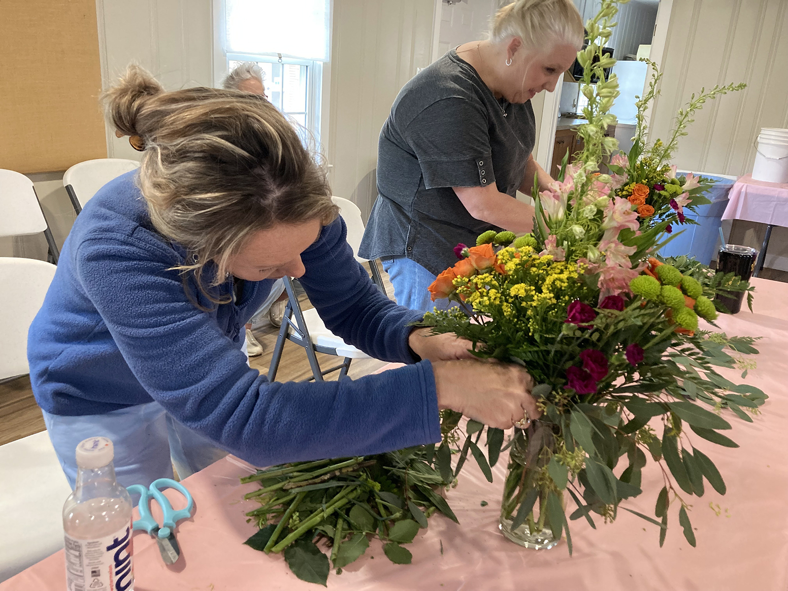 Pessoas participam de uma aula de arranjos de flores, sábado, 13 de abril de 2024, em Randall by the River em Norwood, Carolina do Norte. (Foto RNS/Yonat Shimron)