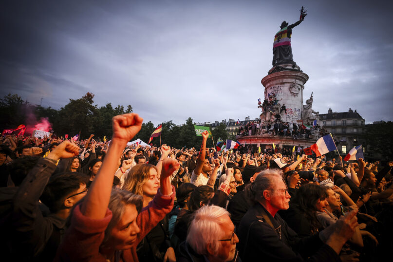 Demonstrators clench their fist during a gathering at Republique plaza in a protest against the far-right, Wednesday, July 3, 2024, in Paris. French opposition parties and associations are trying to block a landslide victory for Marine Le Pen's far-right National Rally in next Sunday's second round of legislative elections. (AP Photo/Thomas Padilla)