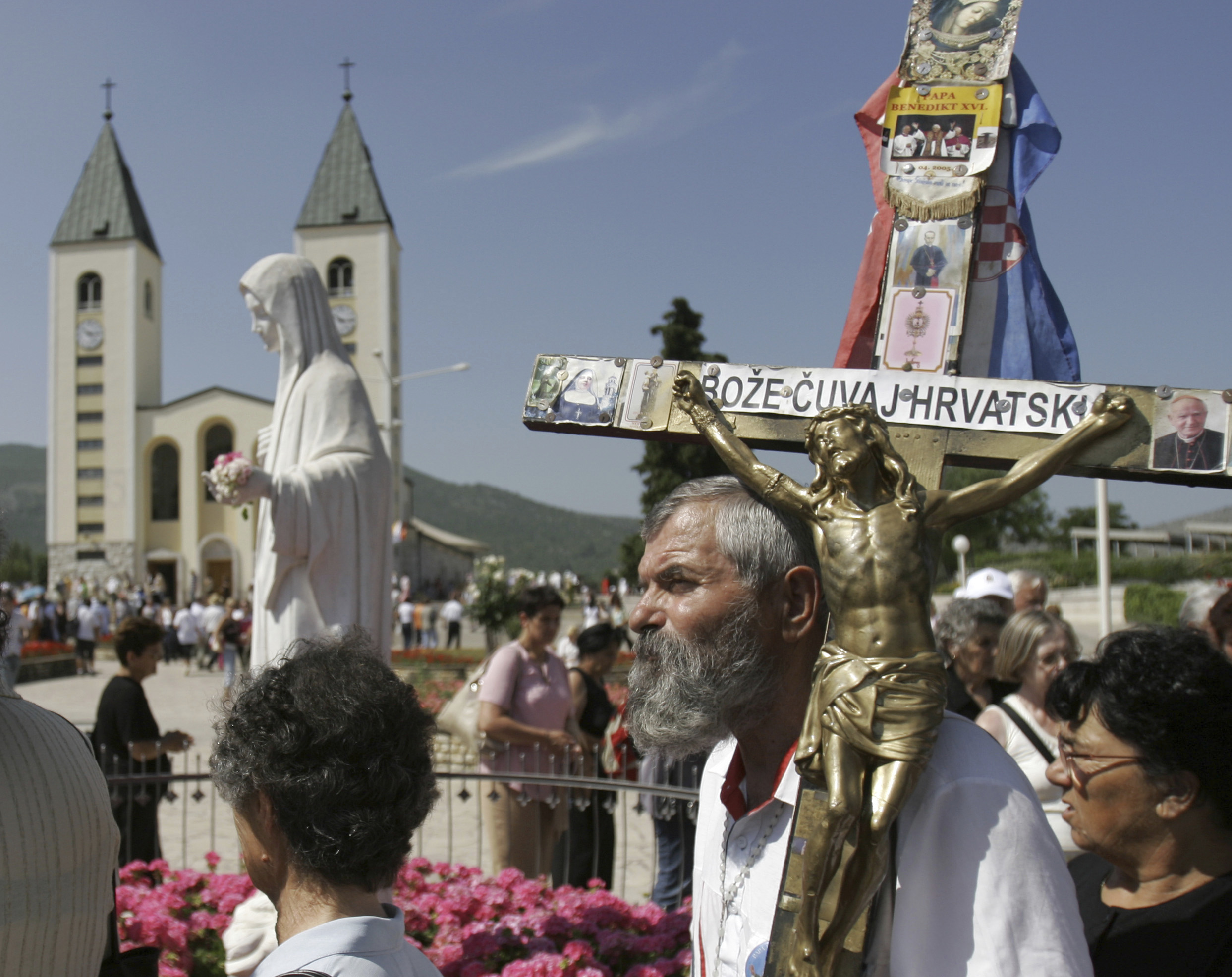 Peregrinos caminham ao redor de uma estátua da Bem-Aventurada Virgem Maria perto da igreja de St. James em Medjugorje, Bósnia e Herzegovina, no domingo, 25 de junho de 2006. (AP Photo/Amel Emric, Arquivo)