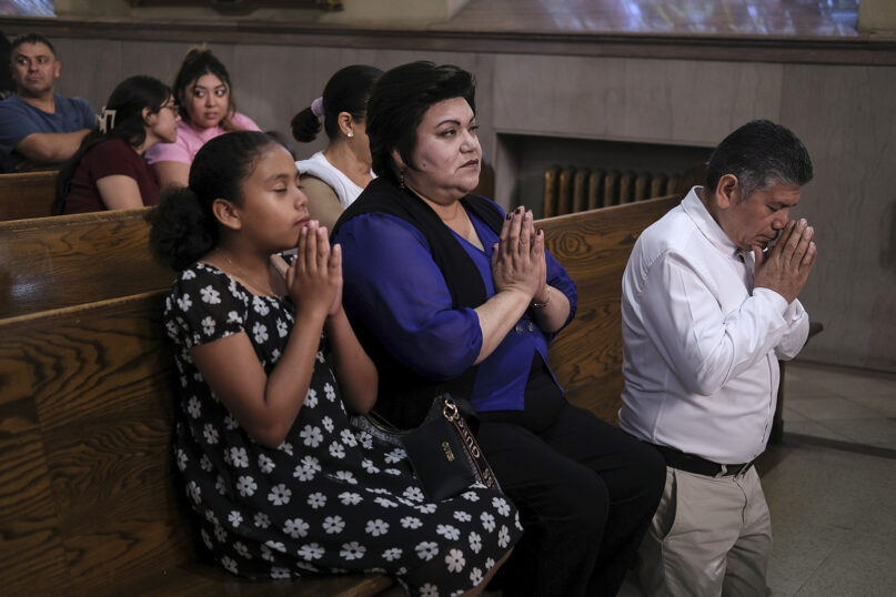 Parishioners Rosa Romero, center, and Jesus Romero, right, pray at St. Peter the Apostle Catholic Church in Reading, Pa., on June 9, 2024. Reading is 67% Latino, according to U.S. Census figures, and home to high concentrations of people of Dominican and Puerto Rican heritage — as well as Colombians and Mexicans, who own restaurants and other businesses around town. (AP Photo/Luis Andres Henao)