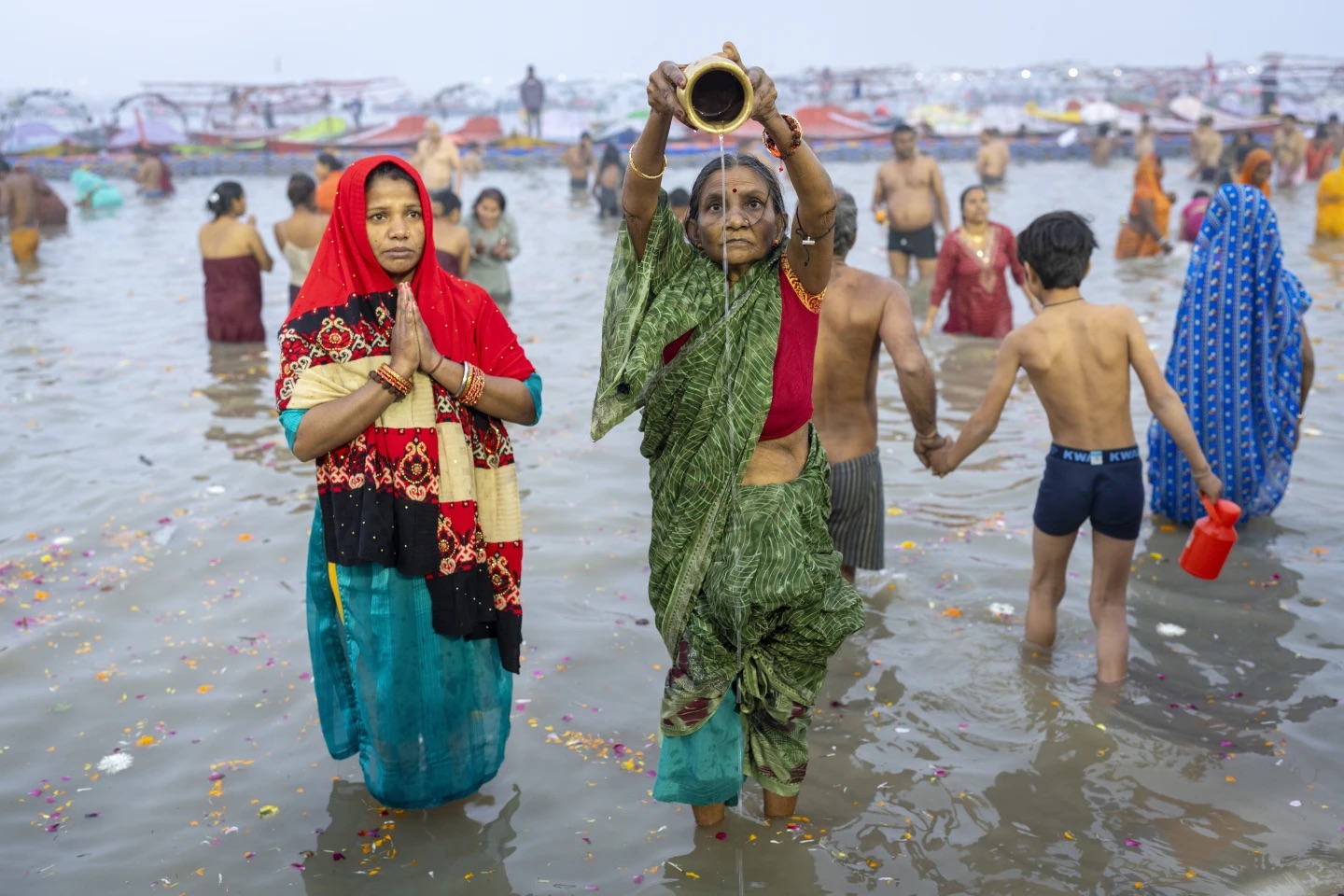 Hindu devotees pray before taking a dip at the confluence of the Ganges, the Yamuna and the mythical Saraswati rivers