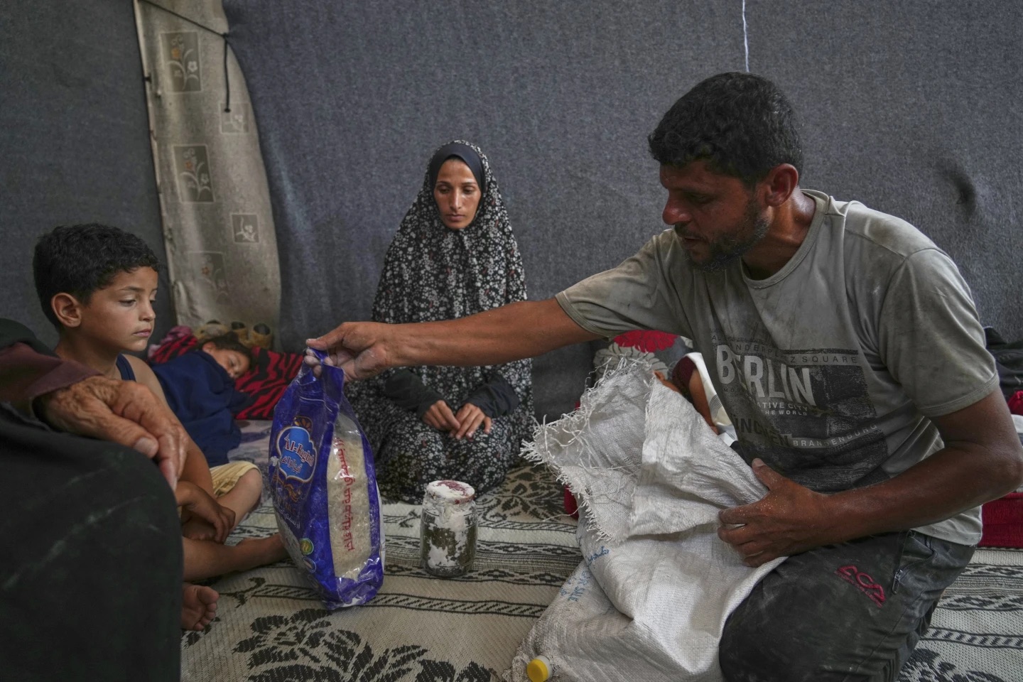 Omar-al-Hobi, 43, from Rafah, unpacks a bag of food
