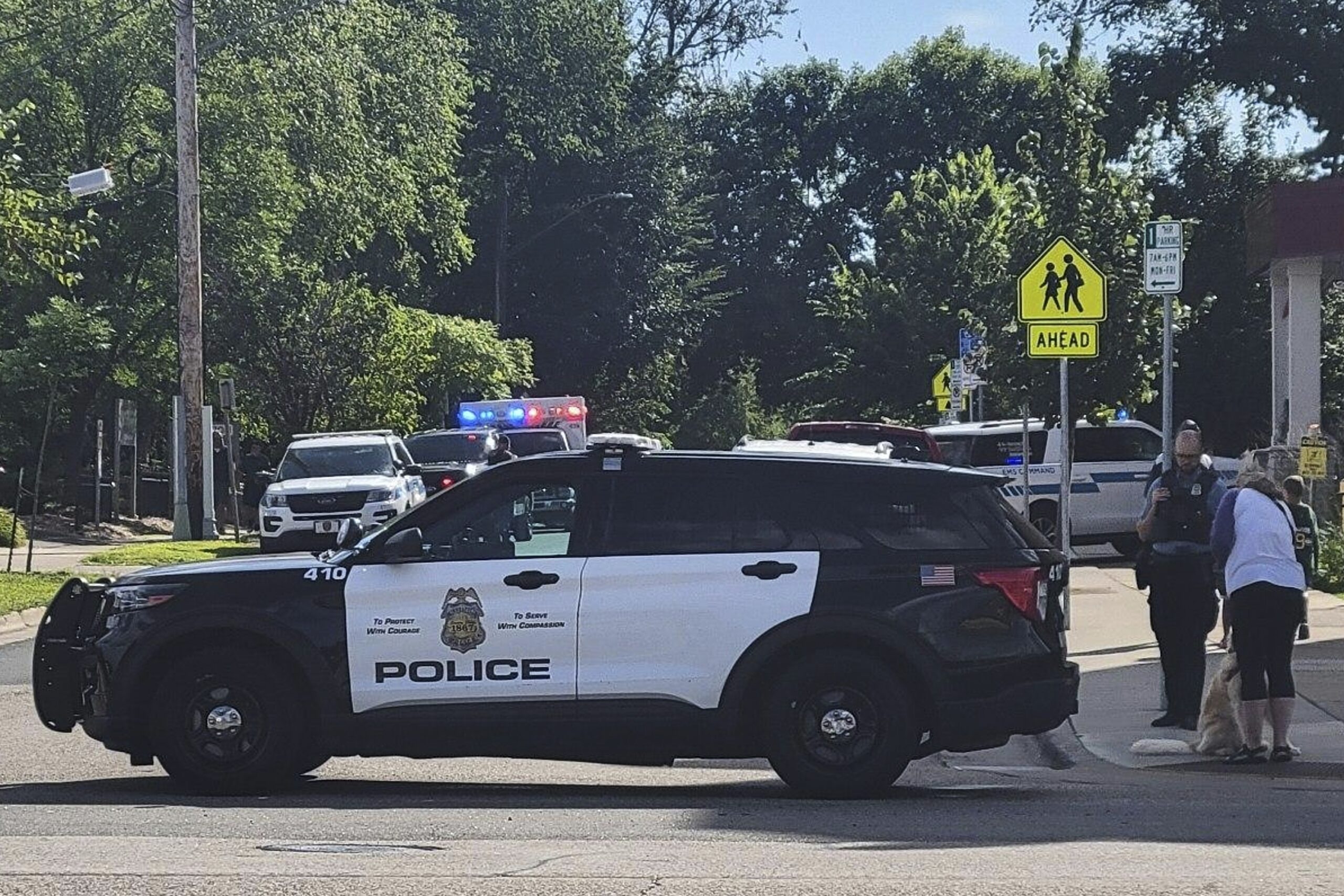 Law enforcement officers gather outside the Annunciation Church's school in response to a reported mass shooting,