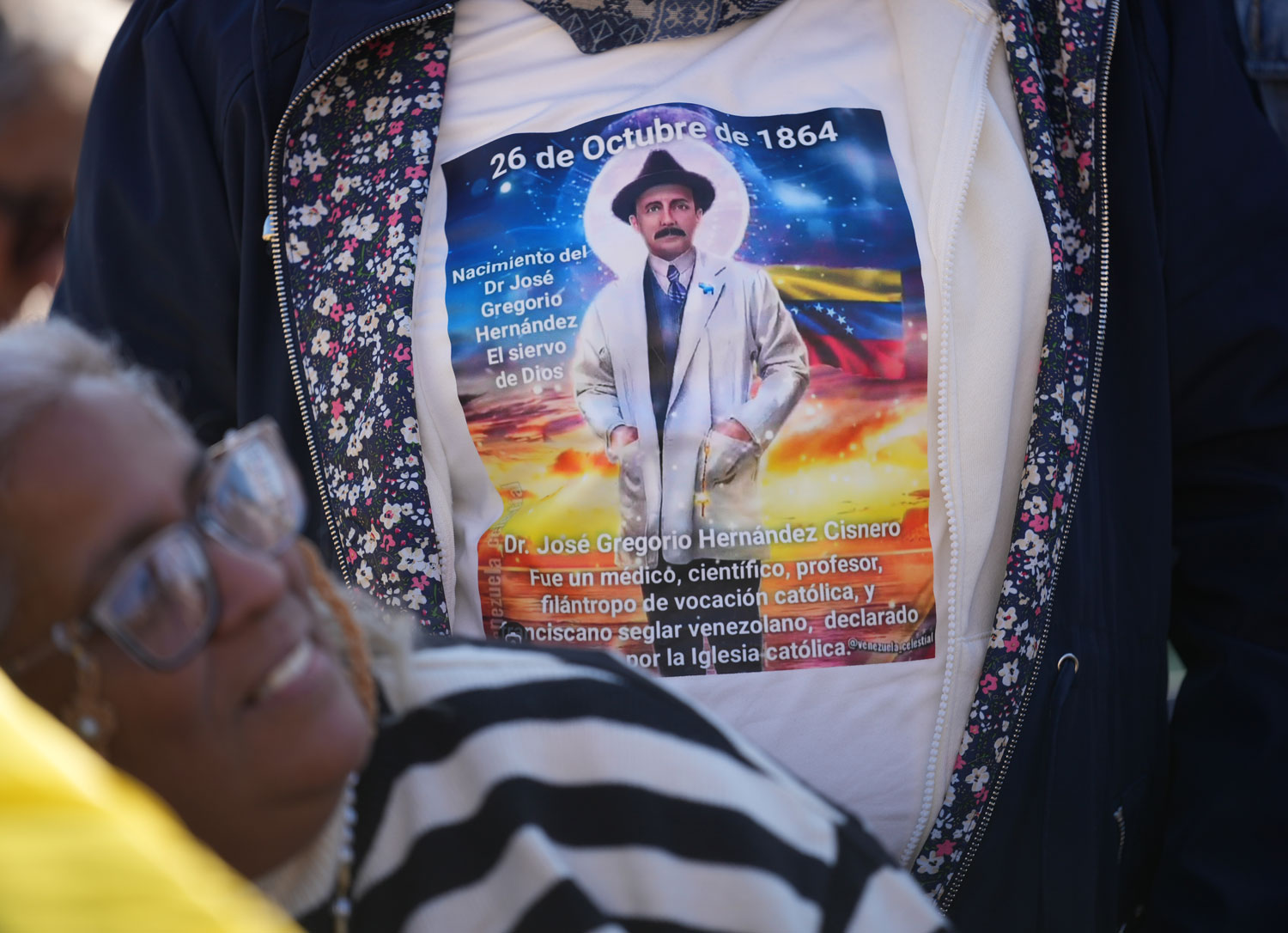 Pilgrims and faithful wearing T-shirts carrying the image of Venezuelan doctor José Gregorio Hernández wait for the arrival of Pope Leo XIV, who presided later that day over a Mass in St. Peter's Square at the Vatican during which he canonized seven new saints of the Catholic Church, including Hernández, Oct. 19, 2025. (AP Photo/Andrew Medichini, File)