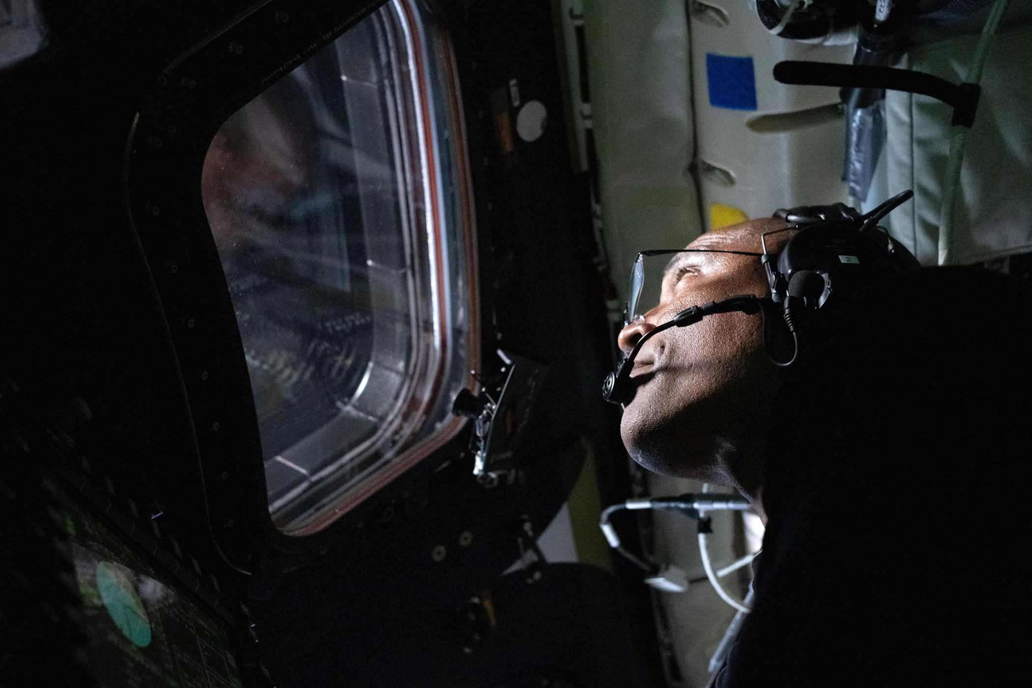 NASA astronaut and Artemis II Pilot Victor Glover peers out the window of the Orion spacecraft during the Artemis II lunar flyby on April 6, 2026. (NASA photo)