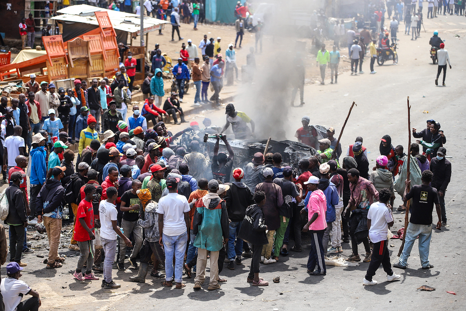 People gather around a burned-out vehicle during a protest over fuel prices in Nairobi, Kenya, May 18, 2026. (AP Photo/Patrick Ngugi)