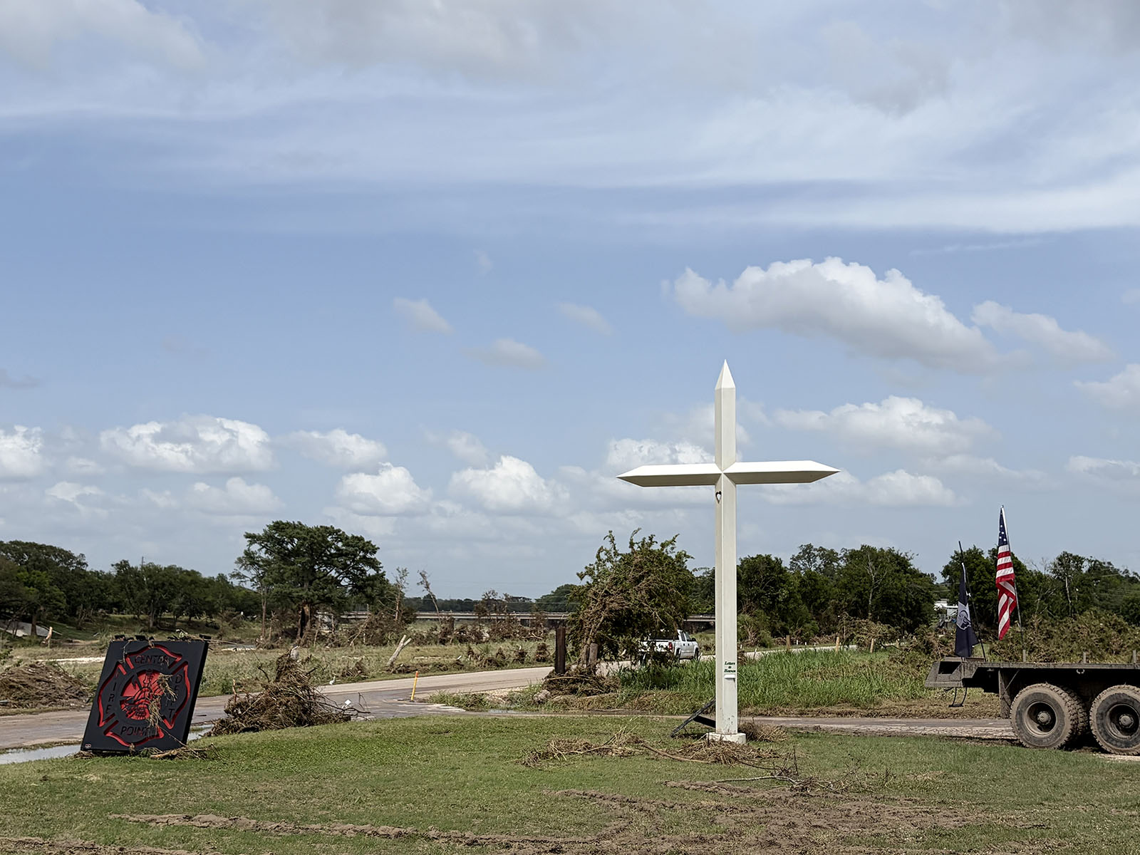 A memorial dedicated to those who died in the Kerr County floods last year stands in front of the Center Point Volunteer Fire Department on July 17, 2026 in Center Point, TX. Twenty-four hours prior, the area was underwater. (Ellie Ashby/RNS photo)